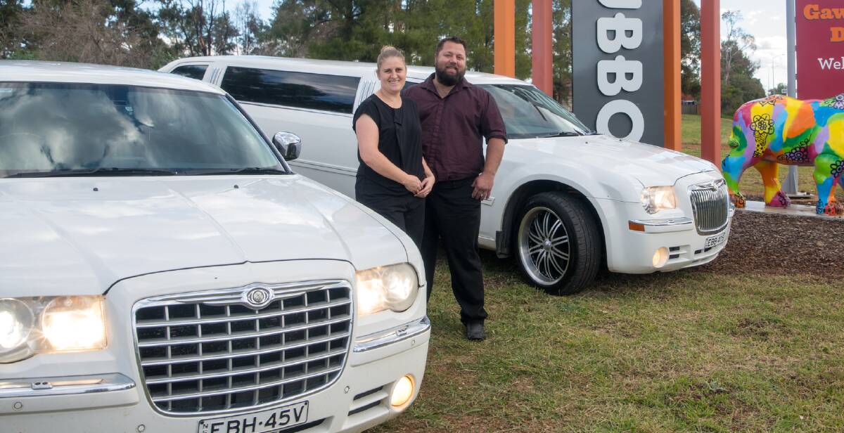 'A GAP IN THE MARKET': Owner of Central West Limousines, Shane Clews, and his wife with two of their Chrysler stretch limos. Picture: Supplied. 