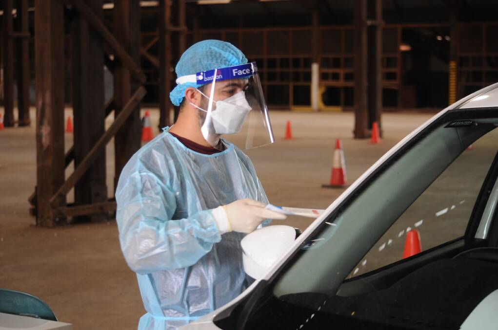 Ram Neupane preparing to administer a PCR test inside the hangar. Picture by Nick Guthrie
