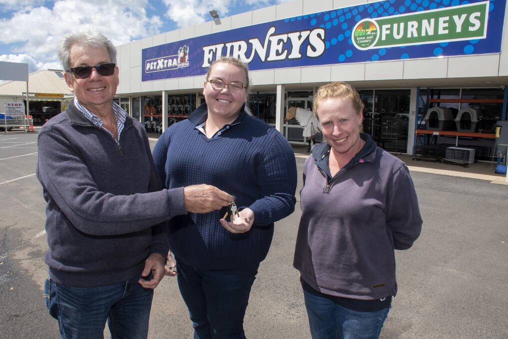 Michael Edwards hands over the keys to the store to new managers Victoria Egan and Cassandra Hayne. Picture by Belinda Soole
