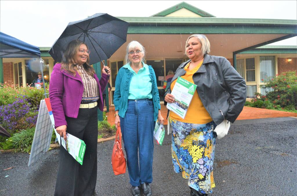 RAINY DAY. Voter Dorothy chats with senator Mehreen Faruqi and candidate Trish Frail. PICTURE: ELIZABETH FRIAS