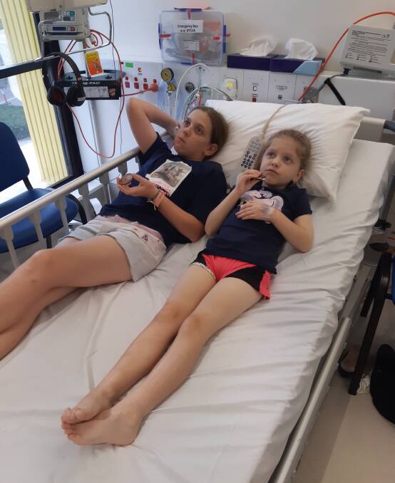 Skyla and Piper Howarth lay on a hospital bed during one of Piper's many treatments. Picture supplied