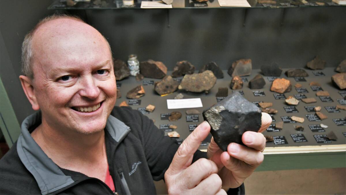 ORIGIN OF LIFE: Bathurst Observatory owner Ray Pickard with a meteorite fragment from his collection. Photo: CHRIS SABROOK 050122cmeteor1a