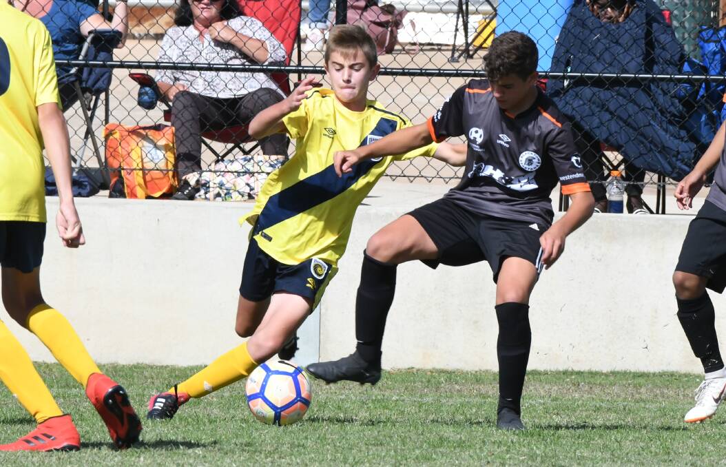 GAME ON: Mariners' ace Jarvis Marat shapes to strip his Blacktown opponent of position in Sunday's under-14 grand final. Photo: CHRIS SEABROOK