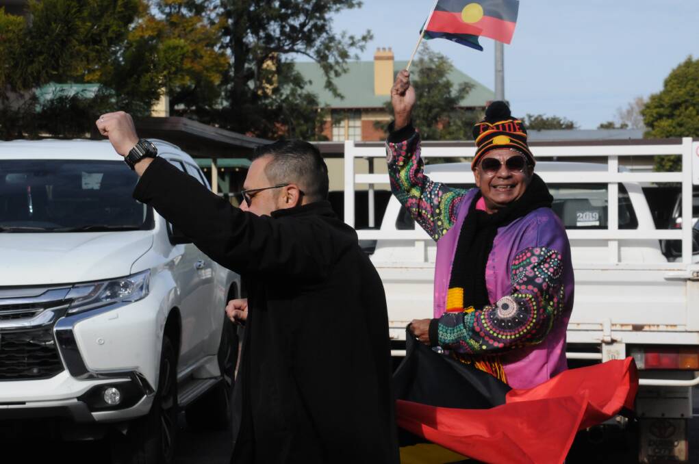 Matthew Hewcar leads the NAIDOC Day march holding the Aboriginal flag proudly. Picture by Ciara Bastow 