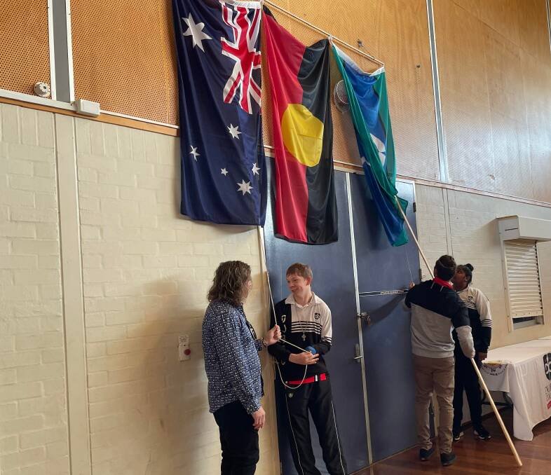 Students raised the Australian, Aboriginal and Torres Strait Islander flags. Picture: Ciara Bastow 