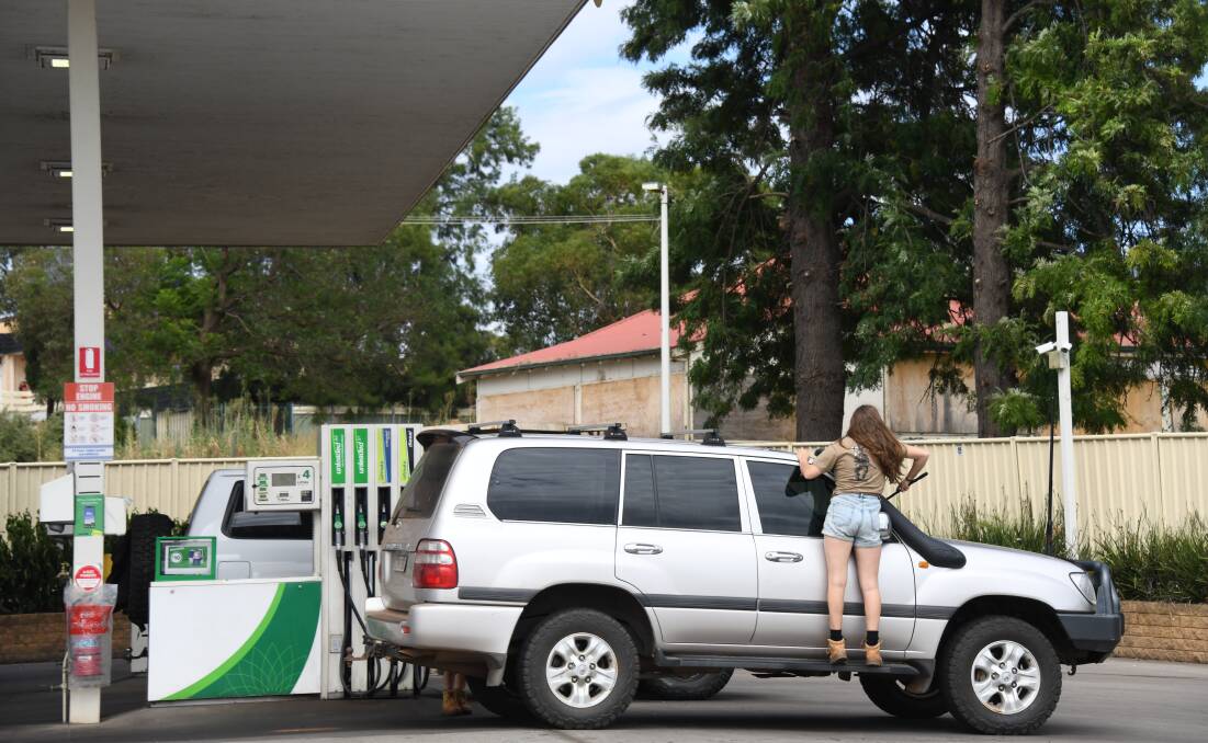 One resident cleans her window after filling up in Dubbo. Picture by Amy McIntyre 
