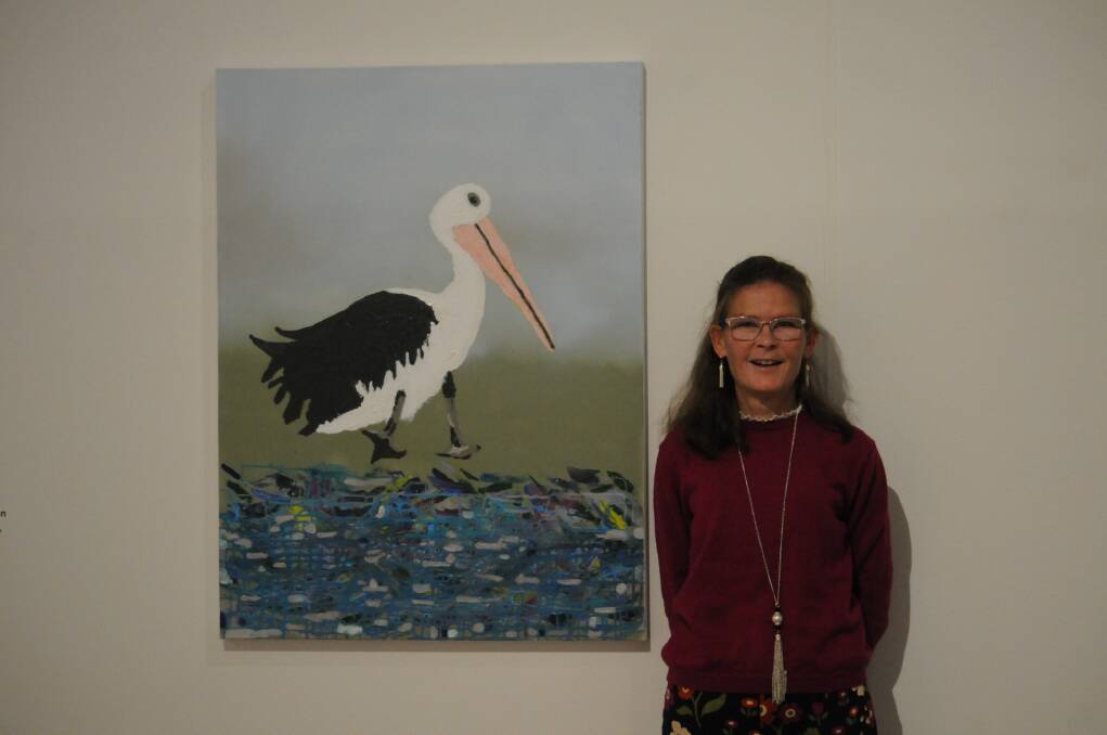 Kate Kenworthy standing with one of her artworks depicting the Bell River at Wellington that is visited by a pelican. Picture by Ciara Bastow 