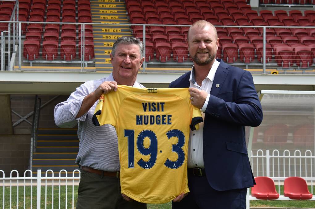 RETURN: Mid-Western Regional Council Mayor Des Kennedy with Central Coast Mariners CEO Shaun Mielekamp holding a commemorative jersey on Glen Willow's pitch. Picture: JAY-ANNA MOBBS