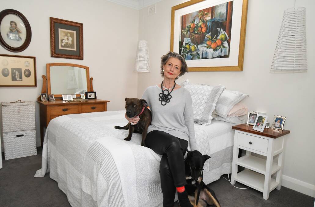 FAMILY: Kath Logan with her dogs Gordon and Bert in the room where she cared for her mother, Mary Sheldon. Photo: JUDE KEOGH 0905jkpal1