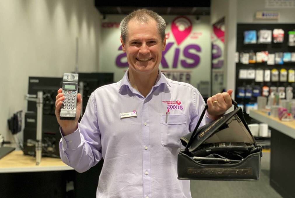 FIRST PHONE: Mathew Dickerson, with the first mobile phone sold in Dubbo, the NEC P3 and a popular phone of the time, a Motorola Bag Phone. Photo: SUPPLIED