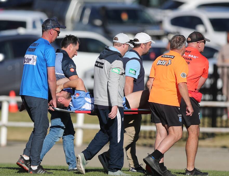 SAD MOMENT: Group 10 hooker Nick Loader is carried from the field after injuring his right leg after four minutes of Saturday's match with Group 11. Photo: PHIL BLATCH