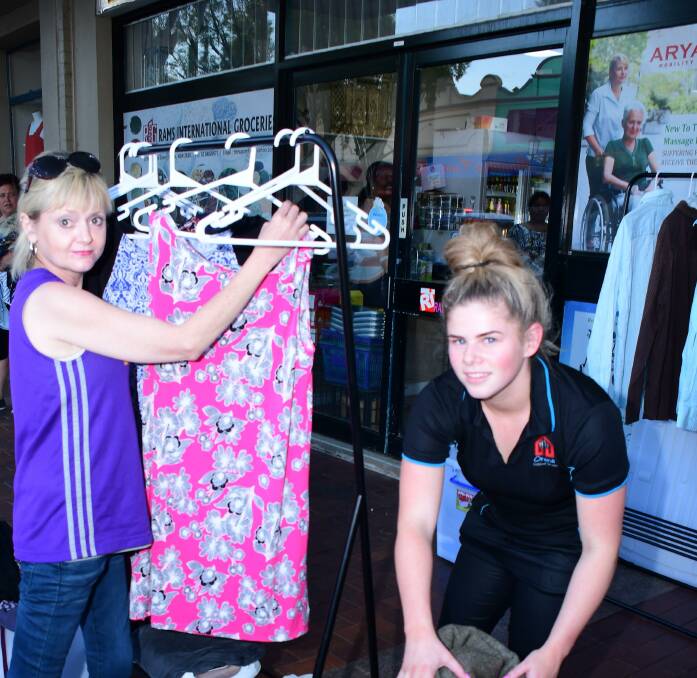 OFFERING CLOTHES: Kind volunteer Liz Bernie and Brooke Williams from Orana Support Service prepare for the inaugural gathering. Photo: BELINDA SOOLE