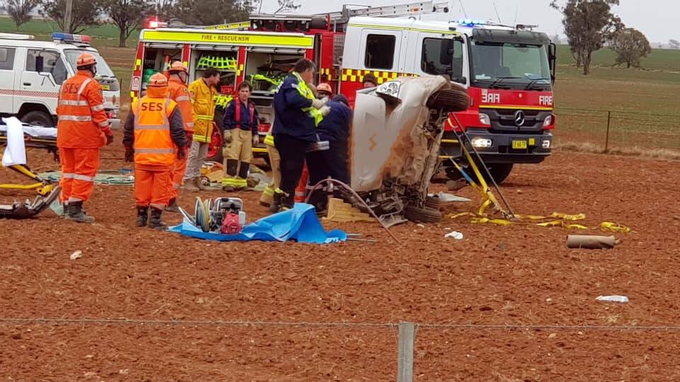 CRASH: Emergency services crews rescue a man from vehicle that flipped in a paddock near Peak Hill on Sunday. Photos: NSW Police