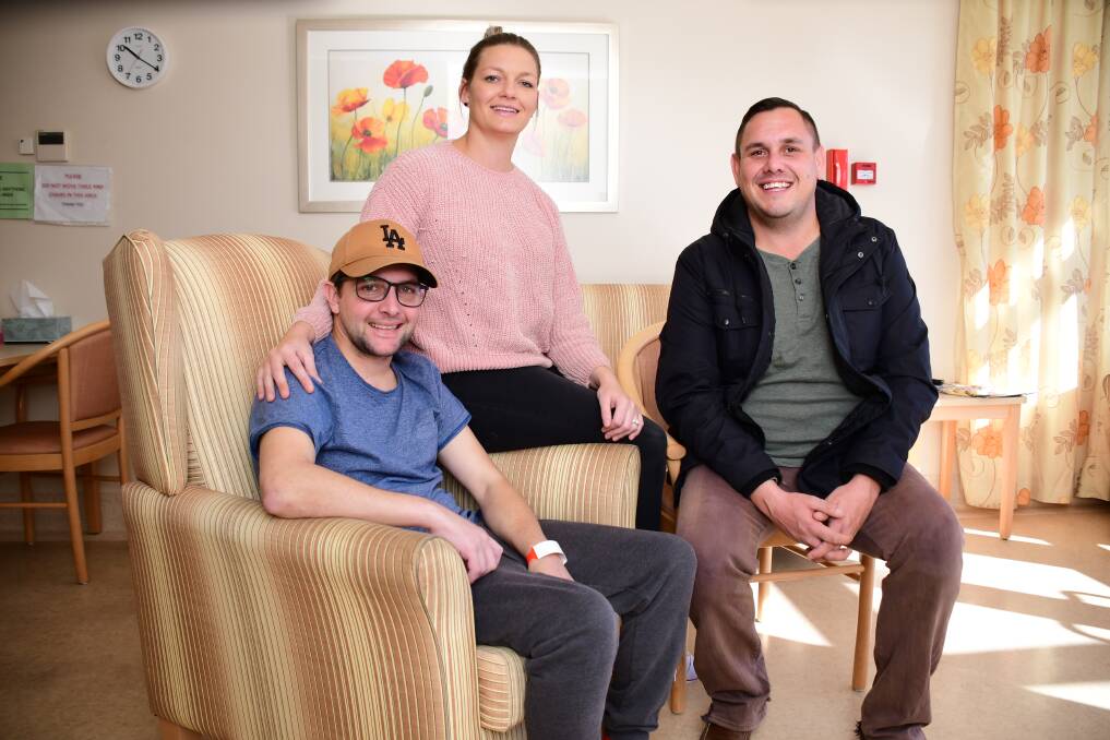 LUCKY MAN: Jockey Michael Hackett with wife Lee and friend Ben Smith in Lourdes Hospital after his fall at the Tomingley races in April. Photo: BELINDA SOOLE