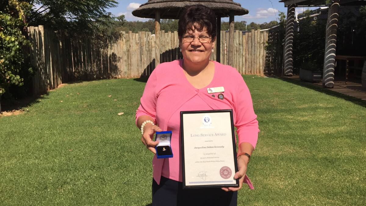 LOYALTY RECOGNISED: Jacqueline Kennedy proudly showcases the medal and certificate she received from NSW police .