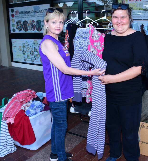 NICE FIND: Volunteer Liz Bernie and Samantha Workman take a look some of the clothing on offer at the Meals on the Main gathering. Photo: BELINDA SOOLE 