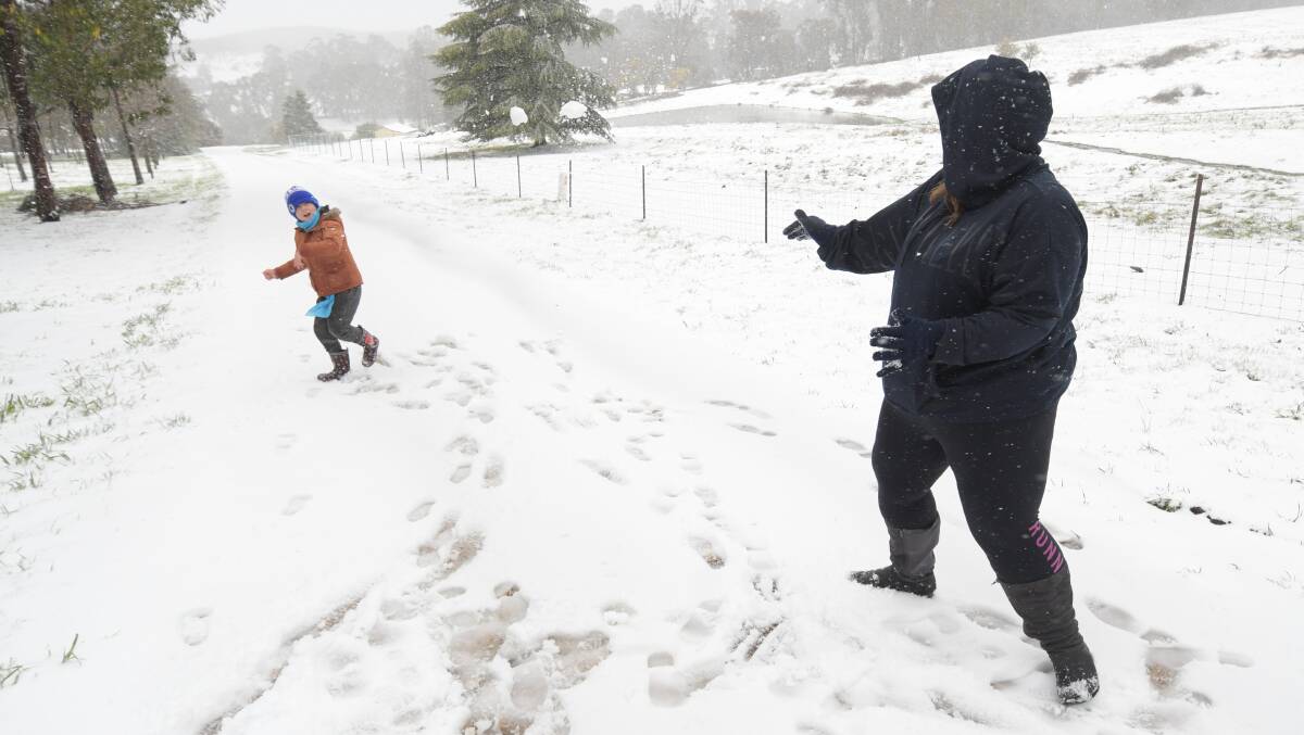 IT'S BACK: Clarry and Bree Bald enjoy a snow ball fight during Orange's last snow falls in August. Photo: JUDE KEOGH
