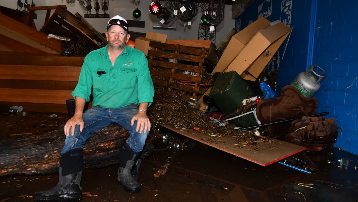 Justin Lampe in his store, where a large log ended up following the flood. Picture by Carla Freedman.