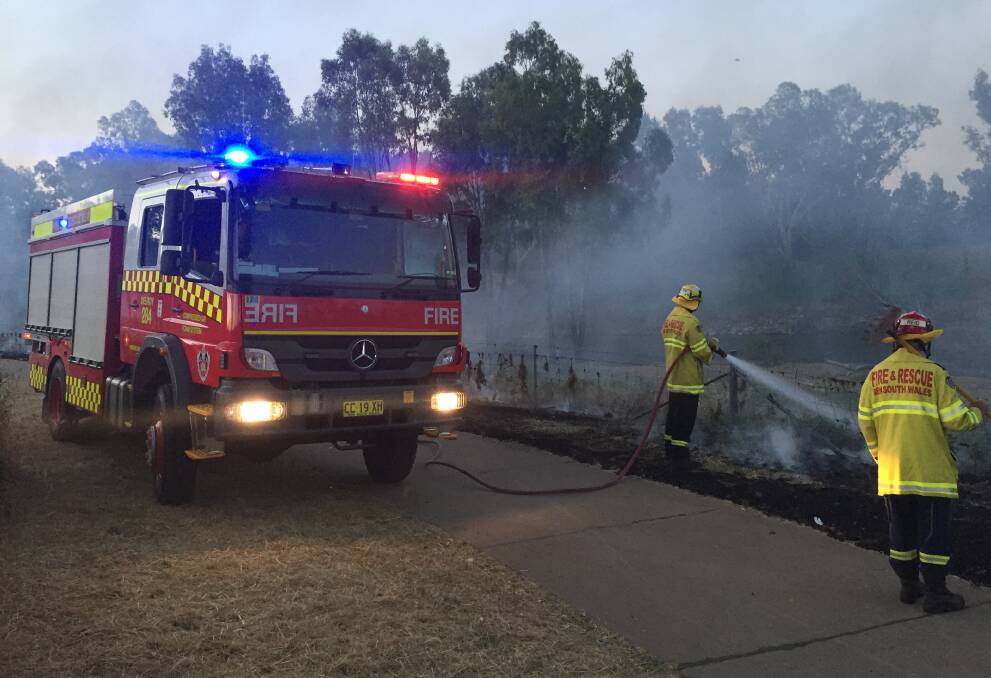 WORKING HARD: Fire officers extinguish a blaze along the bank of the Macquarie River on Monday evening. Photo: BEN WALKER