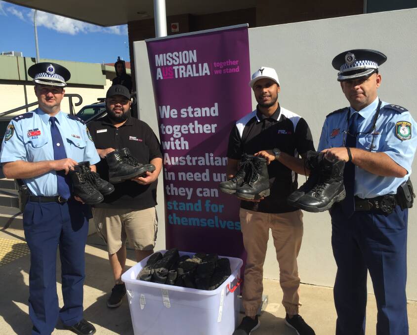 Kind Donation: Acting Superintendent Scott Tanner (left) and Inspector Dan Skelly (right) hand over boots to Errol Toomey and Ray Fuller from Mission Australia. Photo: BEN WALKER