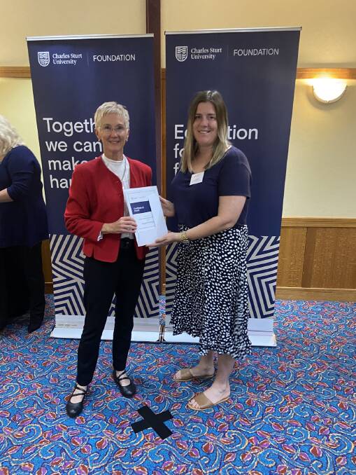 GOOD NEWS: Felicity Taylor-Edwards presenting the Daphne Saxby Taylor Memorial Scholarship to Angela Hanigan. Photo: CONTRIBUTED. 