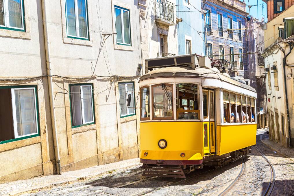 A vintage tram travels the Lisbon city centre in Portugal.