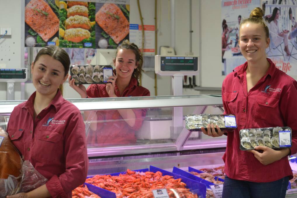 Seafood Feast: Lizzie Mooney, Meg Rosenbaun and Emily Coggan with some of the food locals are buying for Christmas Day. Photo: BROOKE CHANDLER.