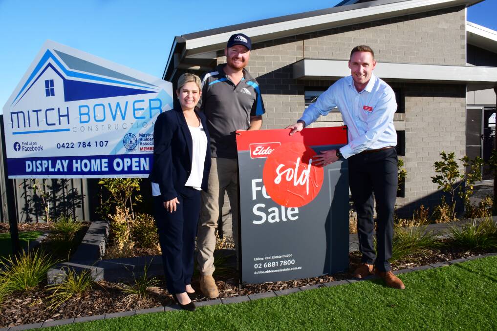 SOLD: Dubbo real-estate agent Adam Wells with Ash and Mitch Bower after selling one of their display homes. PHOTO: BELINDA SOOLE.