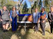 Coonabarabran LALC CEO Brandon Nixon, Crown Lands Group Leader Jacky Wiblin, and Naomi Stanton, Alicia Stanton and Talisha Kuras of Coonabarabran LALC, with the fallen scar tree. Picture supplied