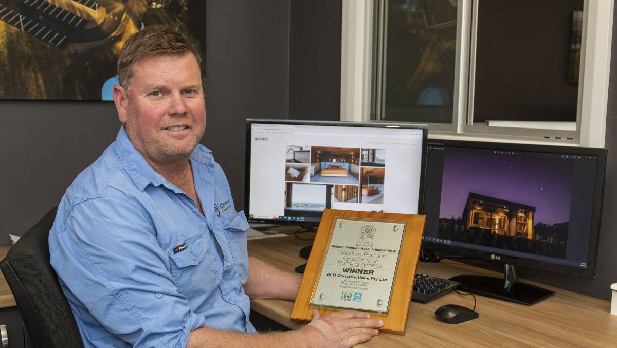 Rob Lister of BLD Constructions sits in his office and holds his award from the Master Builders Association. Picture by Belinda Soole
