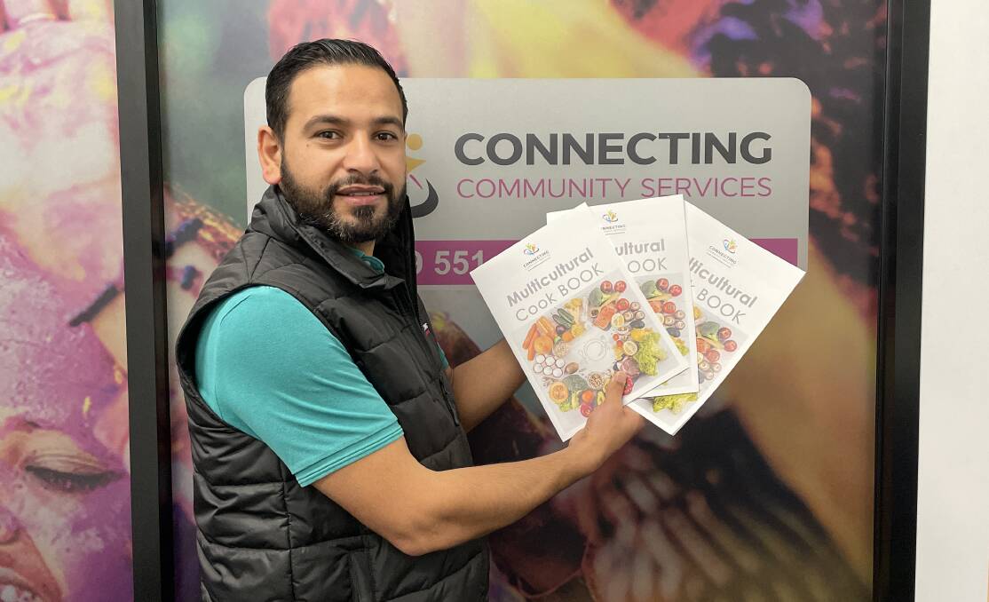 Connecting Community Services migrant support officer Khaled Taleb provides services for immigrants, refugees and asylum seekers in the local area. Here, he is holding the Multicultural Cookbook which was put together to showcase recipes from local residents. Picture by Nick Guthrie