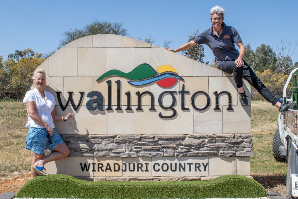 Lisa Thomas, arts curator of Wellington Arts and Emma Knowles, owner of Stone of Arc, at the Wellington town sign which they changed to read 'Wallington' for the picture. Picture by Belinda Soole