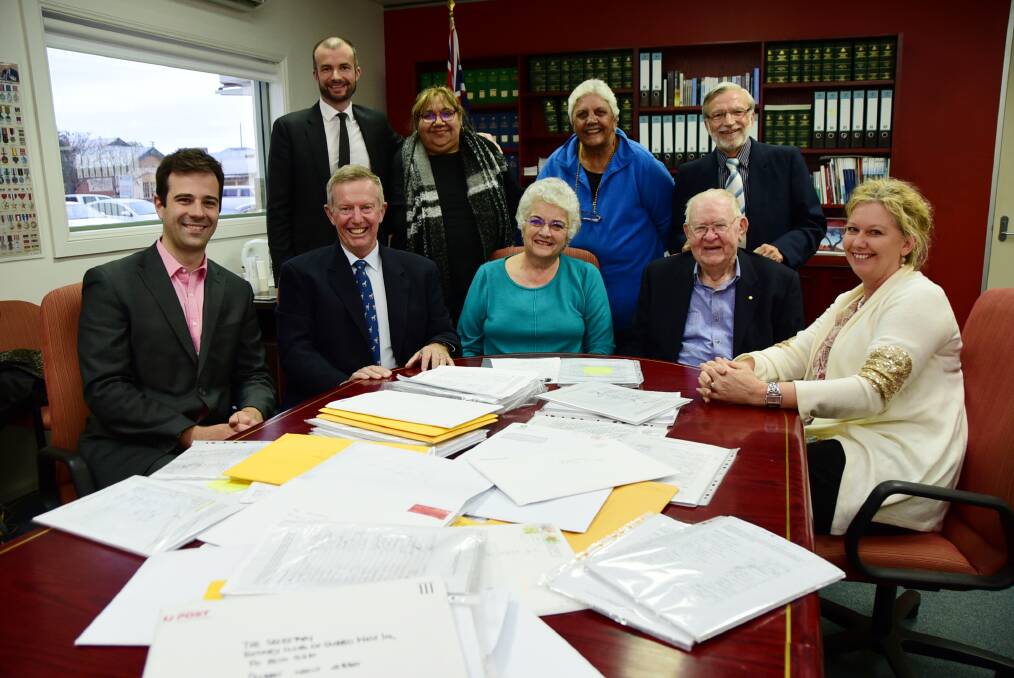TABLE FULL OF SIGNATURES: Robin Payne, Dr Colin McClintock, Franny Peters-Little, Dr Joe Canalese, Dr Florian Honeyball, Mark Coulton, Lyn Smith, Brian Semmler and Michelle Mathison with the signatures collected for a Cancer Centre to be built in Dubbo. Photo: BELINDA SOOLE