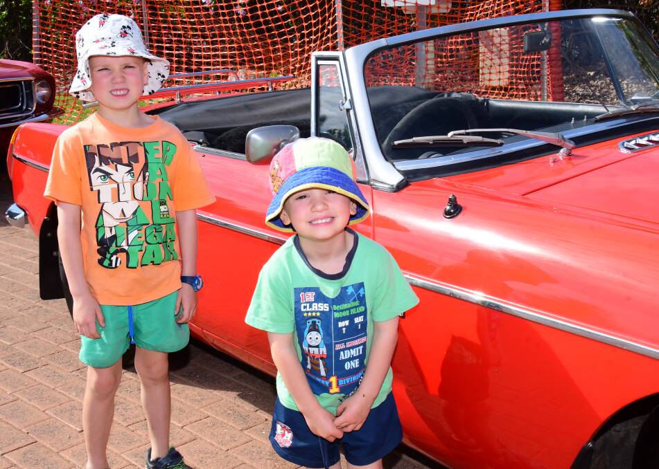 FUN IN THE SUN: Lucas and Brodie Laws keep their eyes on the red convertible. Photo: AMY McINTYRE. 