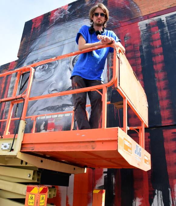 Injection of colour: Matt Adnate is currently working on a portrait of Pearl Gibbs on the corner of Talbragar and Darling streets. Photo: PAIGE WILLIAMS