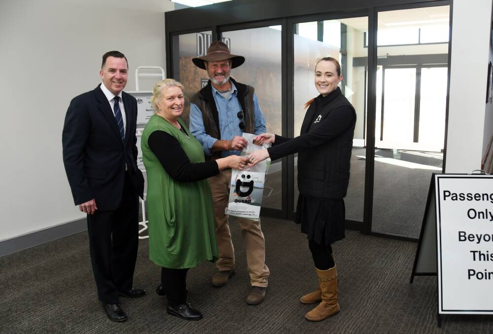 GIFT: Jan Farrar (in green) is greeted by Fly Corporate sales manager Geoff Woodham, husband John, and Katrina Williams who presented a gift from Dubbo Regional Council. Photo: BELINDA SOOLE