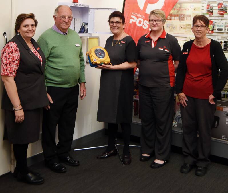 POST OFFICE MILESTONE: Lee-ann Hartley, George Chapman, Virginia Brown, Louise Taylor and Nancy Pascoe with the latest defibrillator to be installed in the city. Photo: BELINDA SOOLE