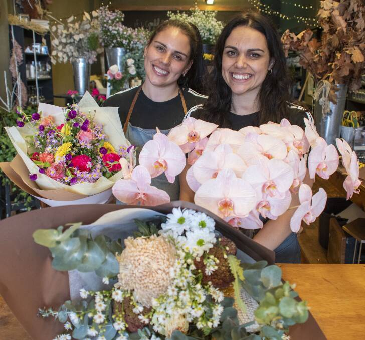 MAKING US SMILE: The Meadow florists Irissa Poga with her sister Elyce, showing some of the flowers that add brightness into people's day. Picture: BELINDA SOOLE
