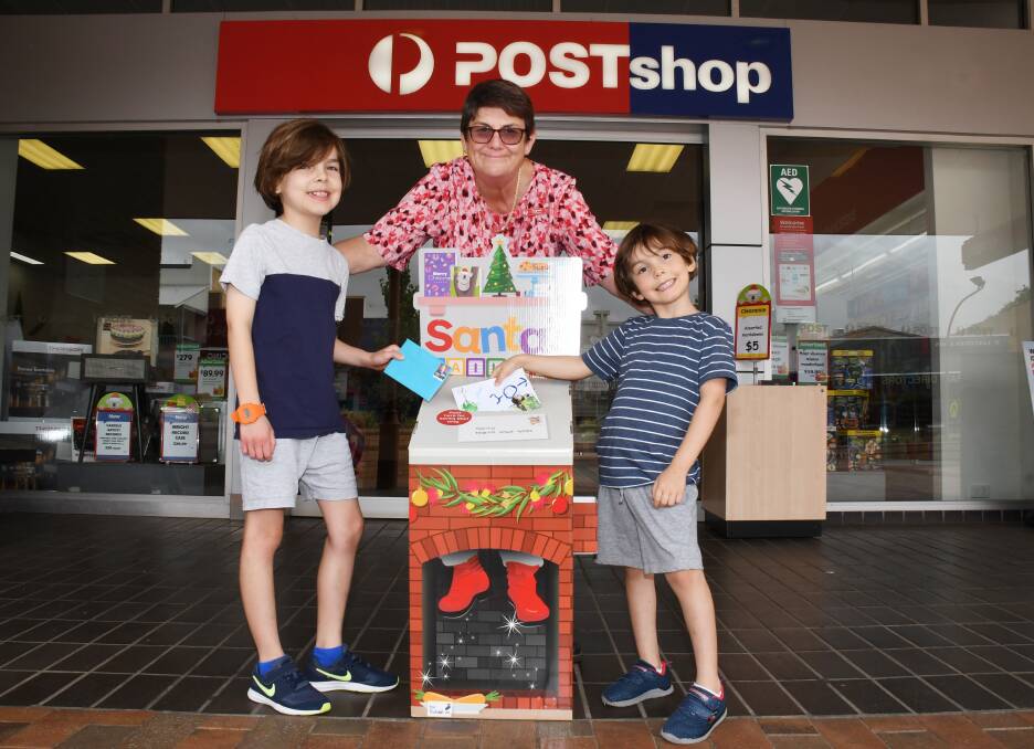 MESSAGE TO SANTA: Noah and Ethan Rich posting their Christmas letters with Australia Post Dubbo manager Virginia Brown. Photo: BELINDA SOOLE