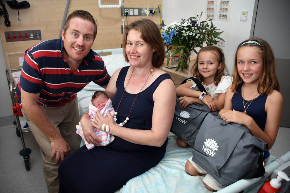 GIFT: Heath, Angus and Tess Webb get one of the Baby Bundles being held by nieces Claudia and Jemima Harrison. Photo: BELINDA SOOLE