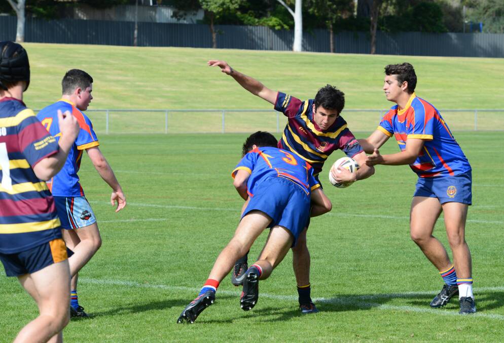 WHACK: Tobias Dries from St Johns College feels the brunt of the James Sheahan College defence. Photo: BELINDA SOOLE