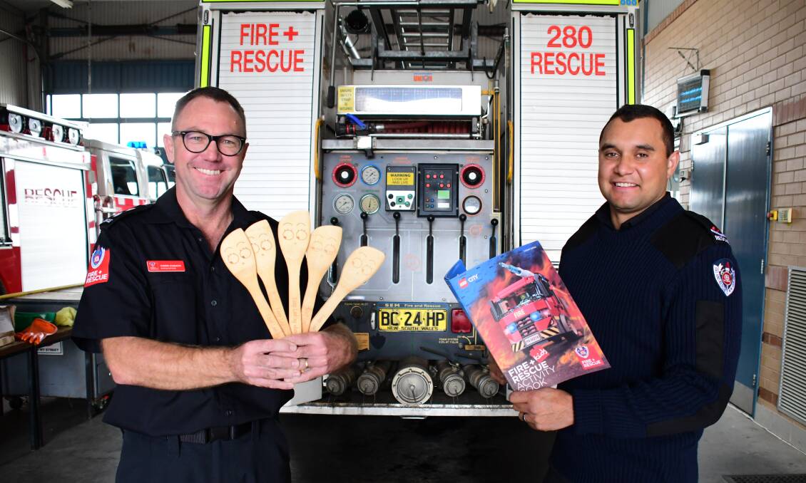 CAMPAIGN: Commander Chris Cusack and firefighter Alex Frail gather together "keep looking when cooking" giveaways including spatulas and children's activity books promoting fire safety. Photo: BELINDA SOOLE