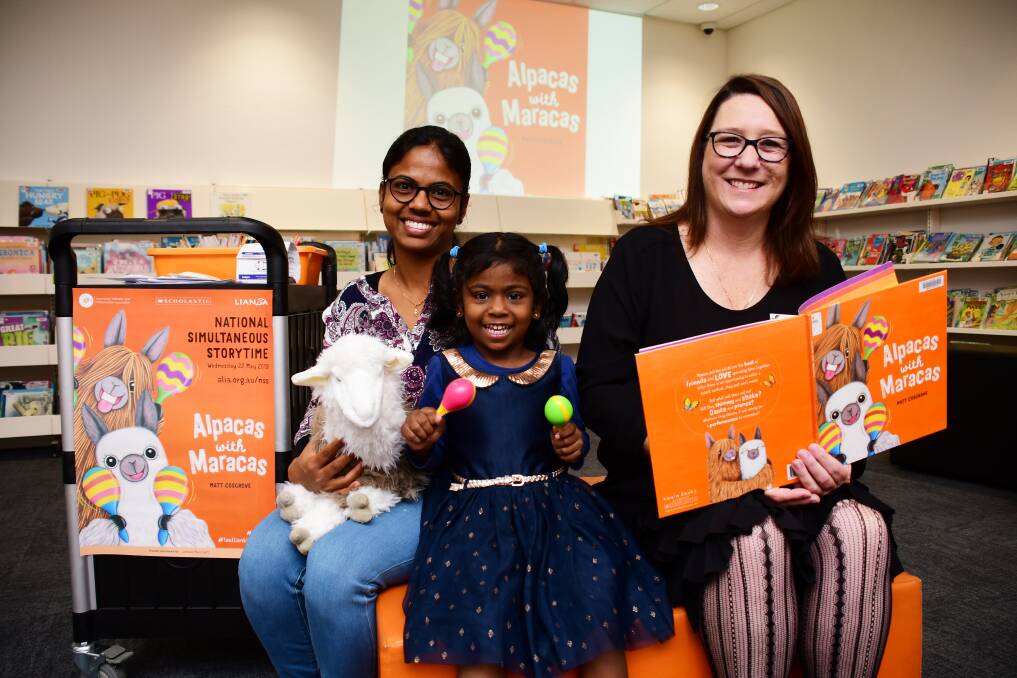 READING TIME: Soumiya and Aathana Prakash with Michaela Owen at Macquarie Regional Library's National Simultaneous Storytime on Wednesday. Photo: BELINDA SOOLE