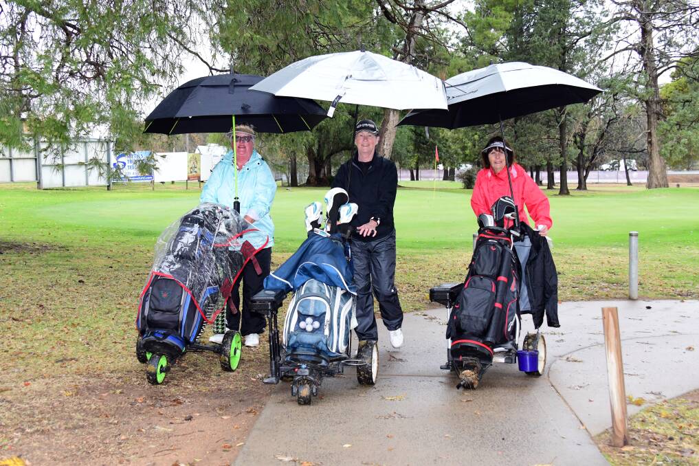 RAIN: Jayne McCormack, Christine Hughes and Jenny Furney enjoy rain and the "Dubbo Veterans Week of Golf". Photo: BELINDA SOOLE