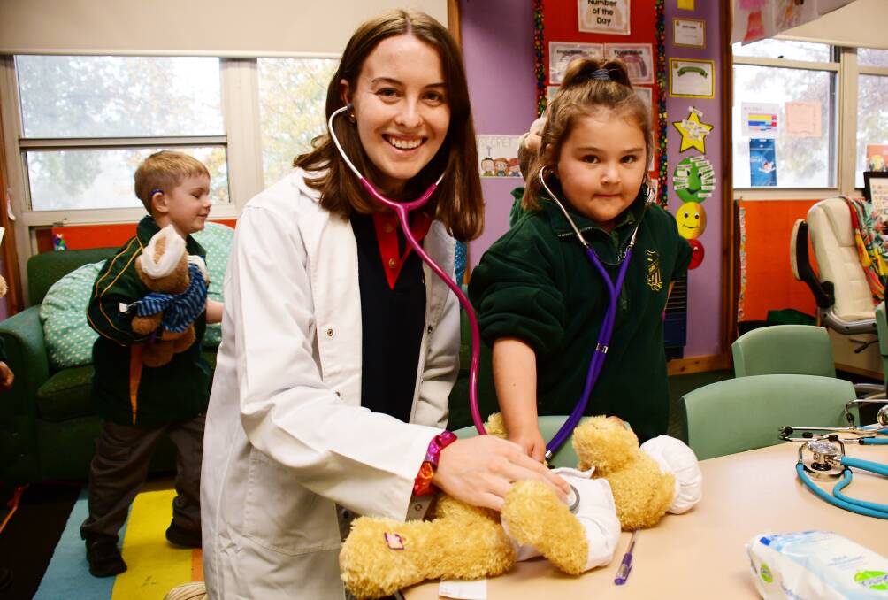 DOCTOR IS IN: Medical student Natalie Klug and kindergarten student Havannah Keevil checking teddy's breathing with a stethoscope. Photo: BELINDA SOOLE