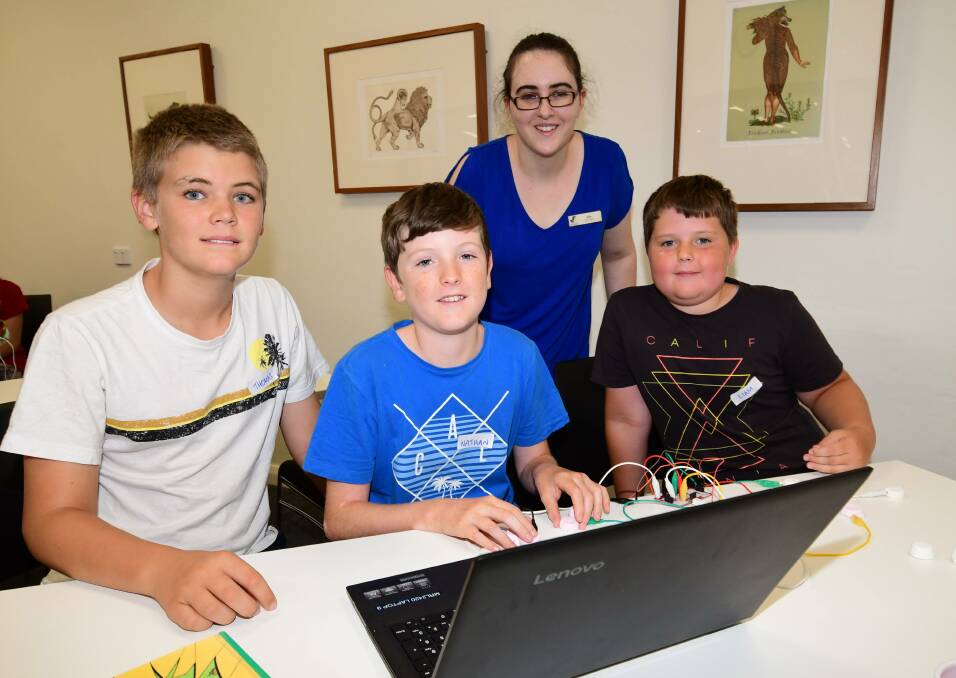 Educational fun: Macquarie Regional Library's Erin Barwick with Thomas Woodcock, Nathan and Liam Crowley during the library's school holiday activities earlier in the year. Photo: BELINDA SOOLE 