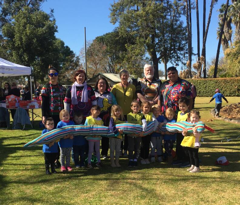 Day of fun and learning: Staff and students from from Allira and Schools as Community Centres with Live Better members hold a giant dreamtime serpent. Photo: Taylor Jurd.  