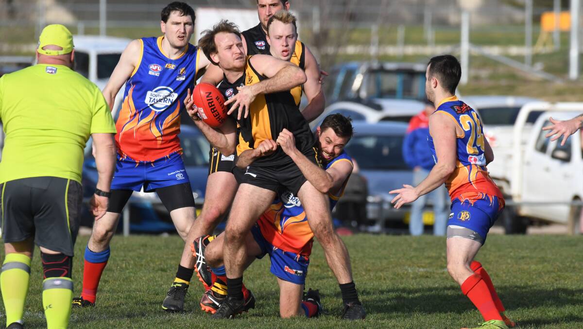 FIGHTING HARD: Pat Taggart is dragged down during the second quarter of the Demons' win. Taggart was one of the Tigers' shining lights on Saturday. Photo: JUDE KEOGH
