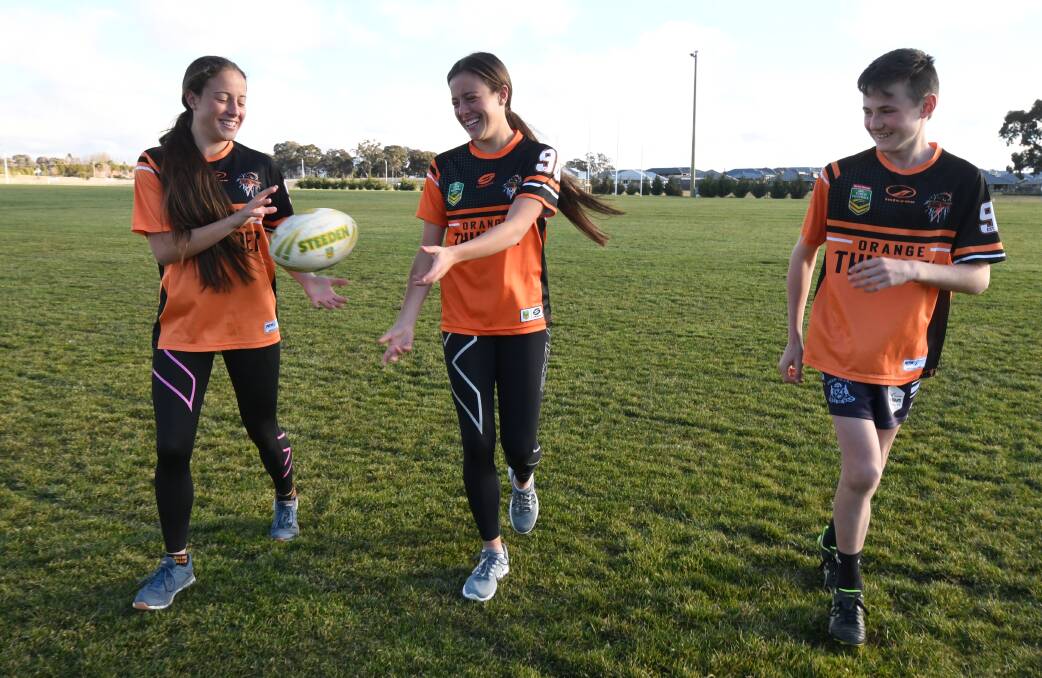 READY FOR ACTION: Under-16 Orange players Caitlin and Hailey Prestwidge with under-14 star-in-waiting Jack Dean. Photo: JUDE KEOGH