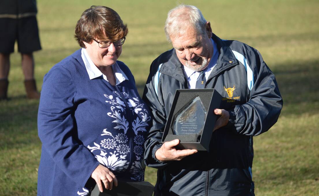 DESERVING: Penny Fisher being presented with life membership to Central West Junior Rugby Union by Peter Veenstra at Endeavour Oval on Monday. Photo: MATT FINDLAY